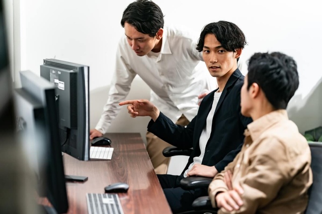 納品までの流れを確認する男性たち